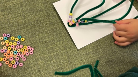 De peuters hebben mooie kerstbomen gemaakt! Door kralen te rijgen aan pijpenragers. πβ¨